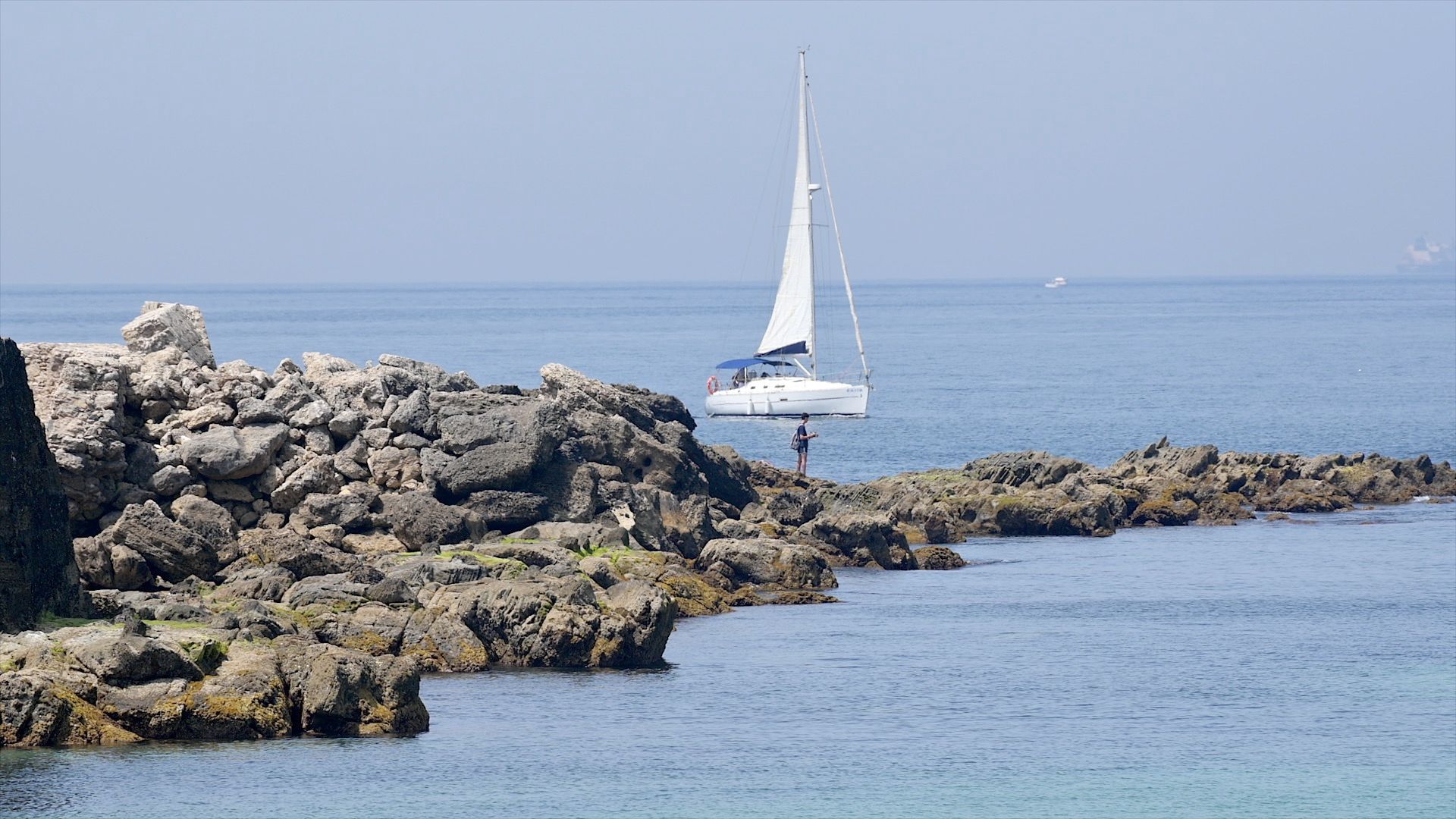 El velero navegando a vela frente a la costa rocosa de Tarifa